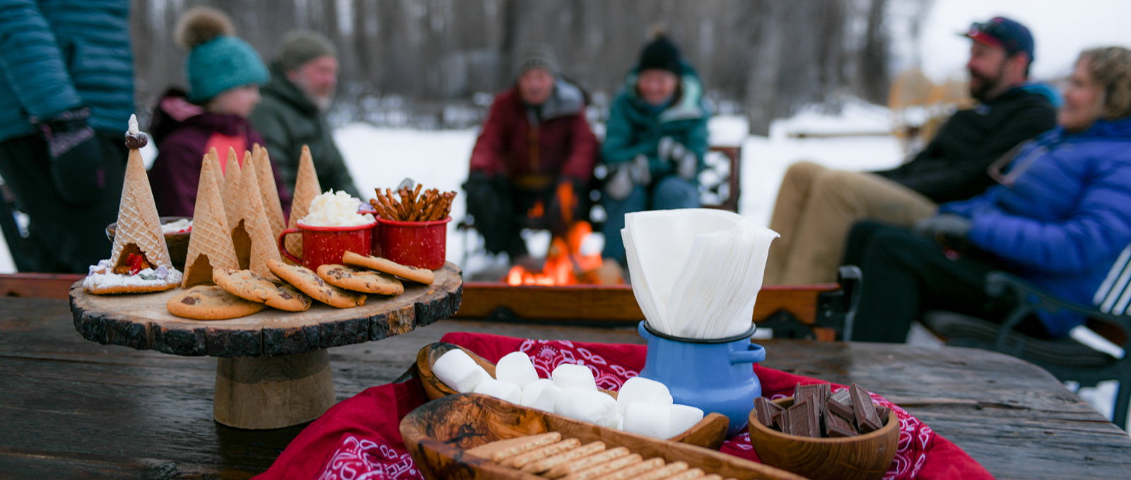 A Dessert Spread With Smores Fixings And Kids Ice Cream Cones Is Displayed In Front Of A Roaring Campfire At Tipi Camp In Jackson Hole